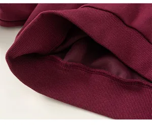 Close-up of elastic ribbed hem and soft fleece lining on a burgundy boys sweater