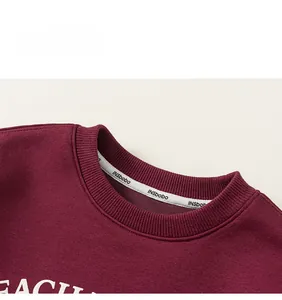 Detail of burgundy crewneck sweatshirt with ribbed collar and letter print