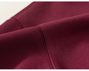 Close-up of burgundy cotton sweatshirt fabric showing premium double-stitched knit texture