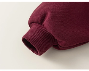 Detail shot of deep burgundy ribbed cuff on high-quality boys' long sleeve sweatshirt
