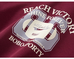 Detail showing the burgundy cotton knit fabric and high-quality letter prints on the sweatshirt