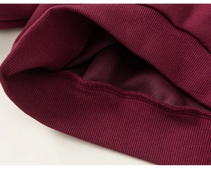 Detail of burgundy kid sweatshirt showing soft fleece lining and ribbed knit cuffs