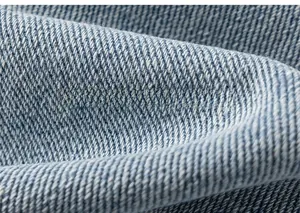 Gros plan sur la texture du denim bleu clair montrant les détails du tissage en coton
