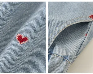 Détail du jean bleu clair pour filles avec broderie cœur rouge et poches latérales utiles