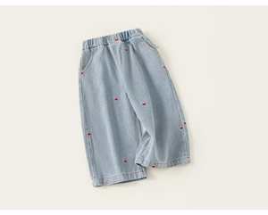 Détail du pantalon en jean pour filles avec broderie de cœur rouge et taille élastique