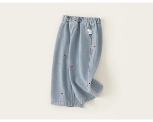 Vue détaillée de la taille élastique et des broderies cœur rouge sur le jean en denim