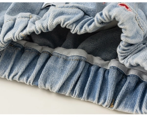 Détail de la taille élastique et de la texture denim du jean large pour enfants