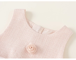 Detailopname van de roze tweed jurkkraag met een 3D satijnen roos en geweven textuur