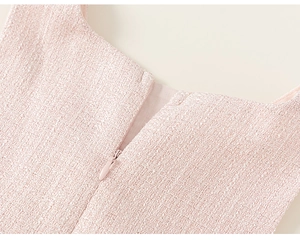 Detail van roze tweed stoftextuur en onzichtbare rits op deze jurk voor kinderen
