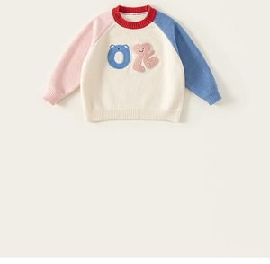 Close-up of kids' round neck knit sweater with colorful sleeves and embroidered OK logo