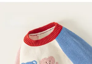 Detail of color-block knit sweater with bear patch and red ribbed neckline for kids