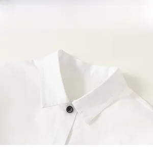 Detailed close-up of a white shirt collar with premium stitching and a black round button