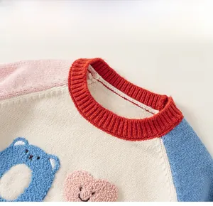 Detail of color-block knit collar and embroidered bear pattern on children's sweater