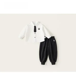 Detailed flat lay of boys white long-sleeve shirt with tie and black joggers set