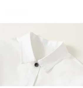 Detail of white cotton shirt collar with black button and minimalist typography print