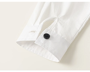 Detailed close-up of white cotton shirt cuff with neat stitching and a black button