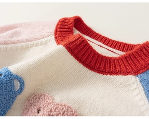 Detail of red ribbed crewneck and multi-color patchwork knitting on a child sweater