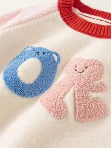 Kids knitted sweater with colorful patchwork sleeves and bear embroidery details