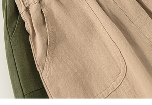 Detail of khaki and olive green kids cotton cargo pants with elastic waist and side pockets