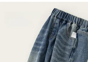 Détail de pantalon en jean bleu pour enfant avec taille élastique et coutures contrastées