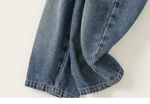 Gros plan détaillé de l'ourlet du jean en denim délavé avec double couture brune