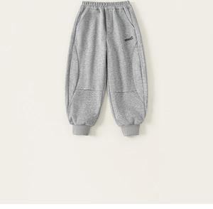 Detail of grey cotton sports trousers showing elastic waistband and printed text on leg