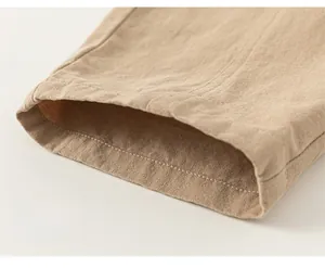 Close-up of loose hem on khaki cotton linen trousers showing natural fabric texture