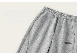 Detail of gray kids joggers showing elastic waist and custom letter embroidery