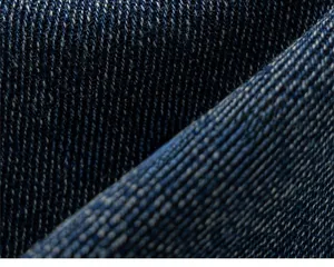 Détail macro du tissu denim sergé bleu foncé doux avec des fibres de coton naturelles