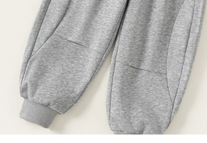 Close-up of grey knit joggers showing ribbed ankle cuffs and soft French Terry texture