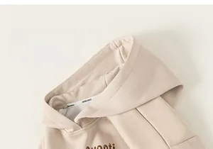 Détail du col d'un sweat à capuche beige en coton avec imprimé Avanti stylé