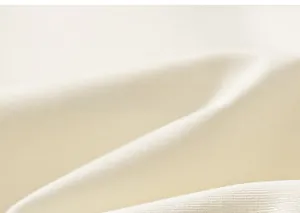 Gros plan du tissu en maille blanc crème montrant une matière en coton douce et aérée