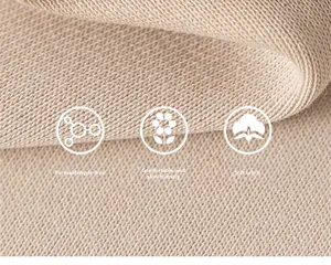 Macro d'un tricot en coton beige doux montrant une texture et une superposition de qualité