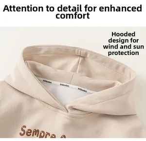 Détail d'un sweat à capuche abricot avec ruban INSbobo et texture en coton doux