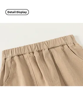 Detail view of khaki cotton trousers featuring elastic waistband and slanted pockets