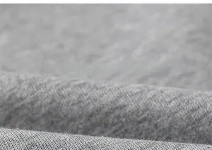 Close-up of soft grey knitted cotton fabric texture with fine weave for casual hoodies