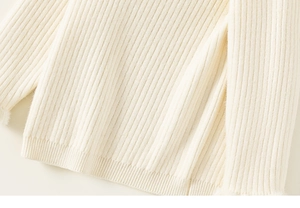 Detailed close-up of girls cream knit sweater showing soft ribbed texture and fine vertical stripes