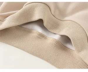 Détail du bas côtelé d'un sweat à capuche beige clair pour enfant en coton tricoté