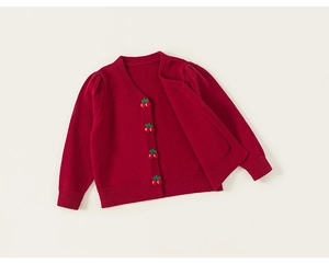 Detail of red knitted cardigan for girls featuring unique 3D cherry-shaped buttons
