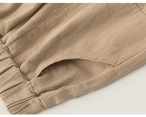 Close-up of khaki cotton twill pants showing elastic waist and side pocket details
