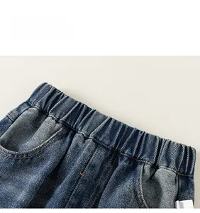 Détail du denim bleu avec taille élastique et coutures précises sur un jean garçon
