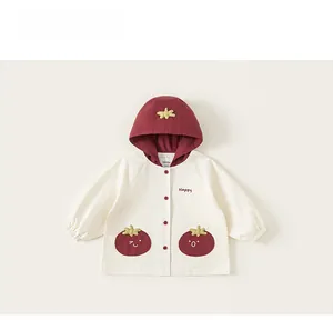 Détail de veste enfant à capuche avec lettrage Happy et poches en forme de tomate