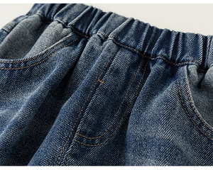 Détail d'un pantalon en jean bleu foncé avec taille élastique et surpiqûres orange