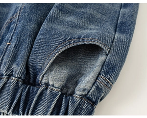 Détail du pantalon en jean bleu avec ourlet élastique et finitions de couture de qualité