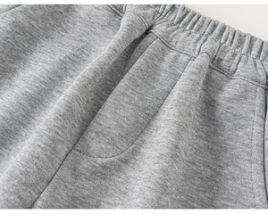 Close-up of grey knit joggers featuring an elastic waistband and drawstring detail