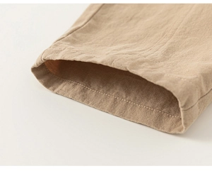 Detailed macro view of khaki cotton linen trousers leg with premium double stitched hem finish