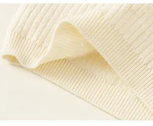 Detail of cream rib-knit sweater hem featuring soft fleece lining and thick texture