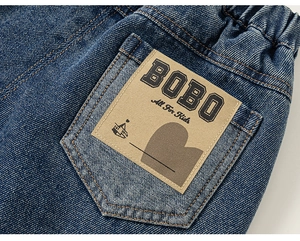 Gros plan d'un pantalon en jean pour garçons avec un patch de marque sur la poche
