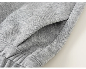Detailed close-up of grey heather knit fabric showing side pocket and ribbed waistband