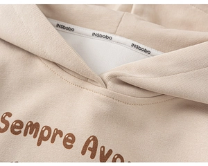 Détail du sweat à capuche crème pour enfant montrant le col et l'imprimé vintage